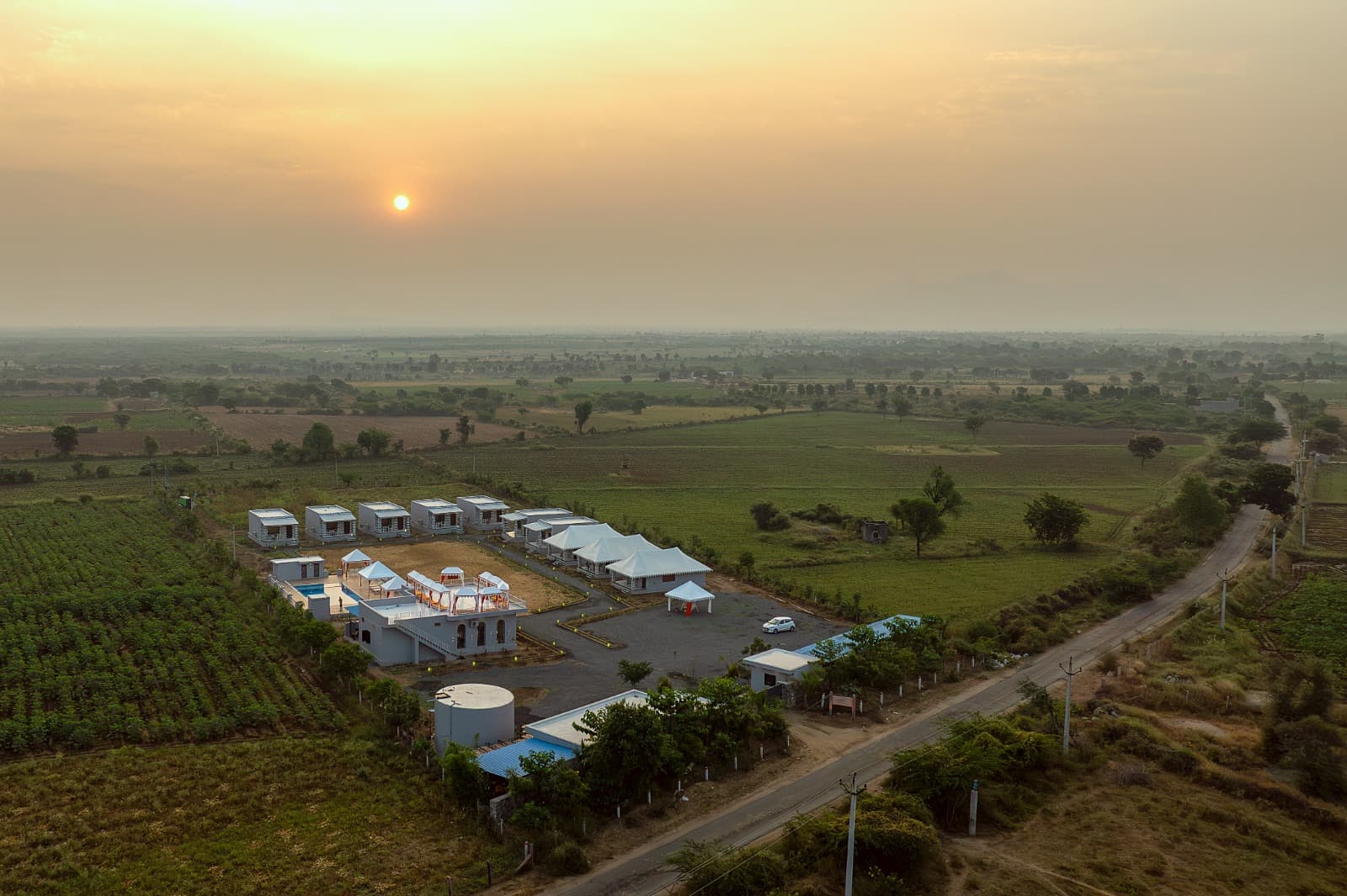 Upvan Jawai at sunrise, a clearing among open fields seen from the air